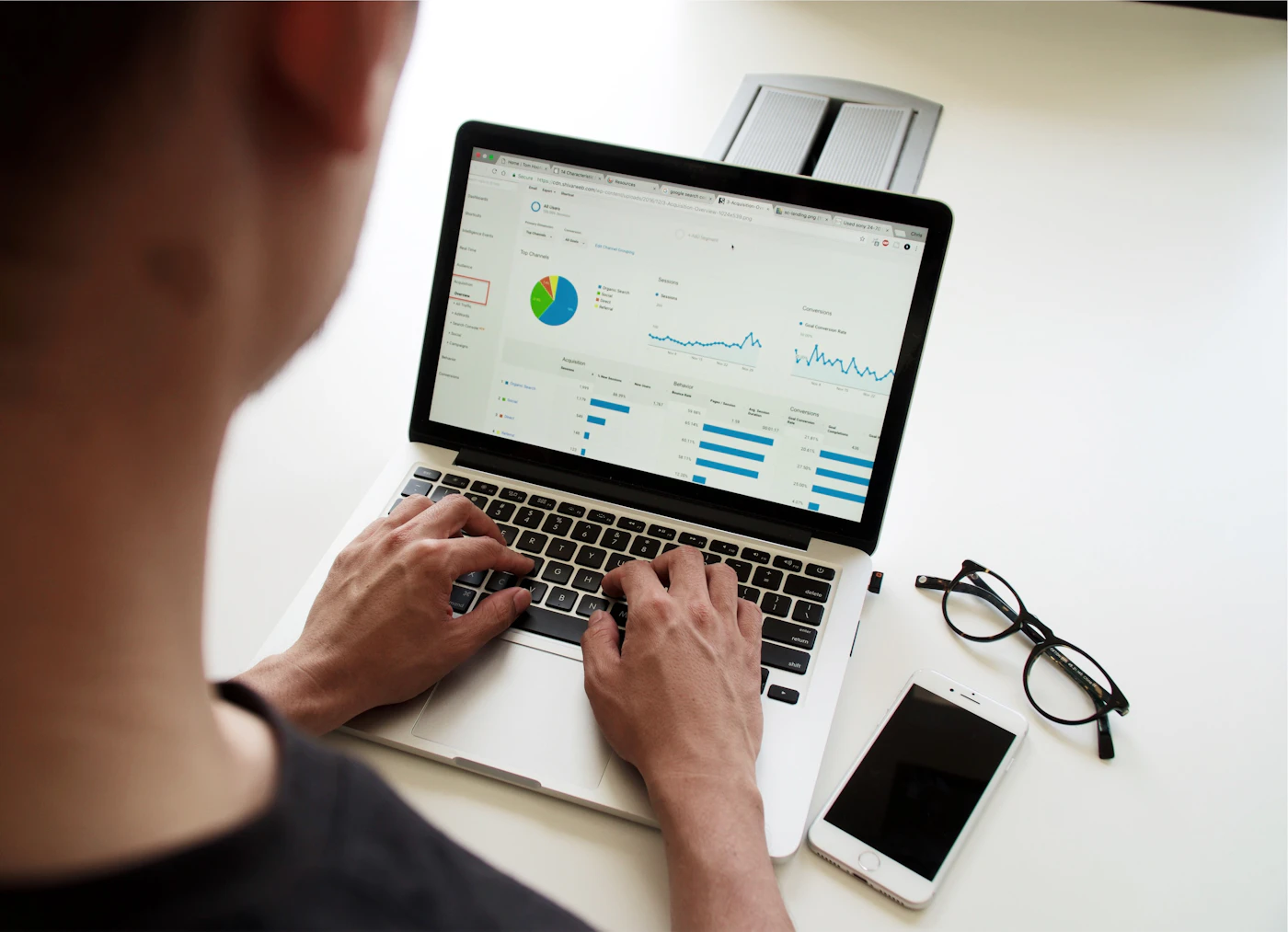 Marketing team reviewing campaign performance around a laptop